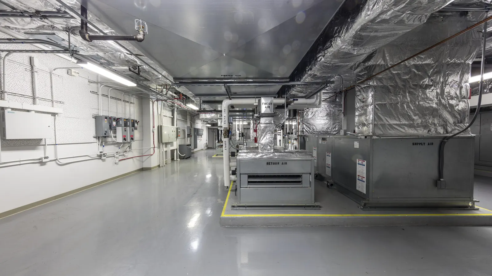 Air handling units and insulated ductwork in the basement mechanical room of a federal building in Los Angeles, the kind of equipment a commercial HVAC assessment logs unit by unit