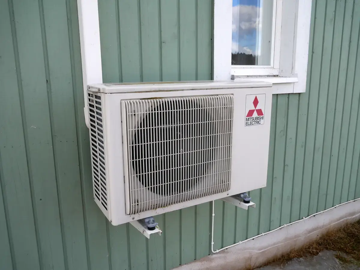 Ductless mini-split outdoor condensing unit mounted on a building wall