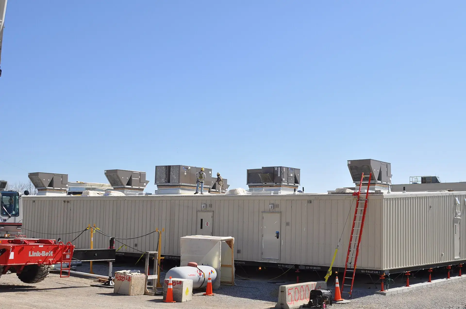 Row of commercial rooftop HVAC units on a building roof